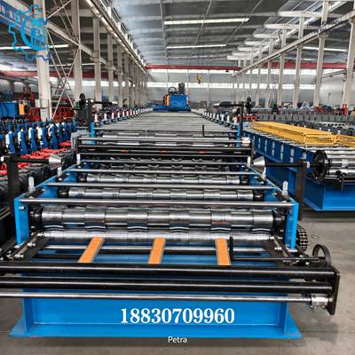 Como una profesional m&aacute;quina para hacer l&aacute;minas de techo, el equipo adopta una estructura industrial en color azul de alta resistencia. Los rodillos de conformado est&aacute;n dispuestos de manera ordenada en una larga l&iacute;nea de producci&oacute;n, garantizando una presi&oacute;n uniforme y un transporte estable de la l&aacute;mina durante el proceso de perfilado continuo. Los bloques gu&iacute;a de color naranja ayudan a dirigir la l&aacute;mina y evitar rayaduras en la superficie. Las manivelas de ajuste laterales y el sistema de transmisi&oacute;n por cadena aseguran una operaci&oacute;n estable y eficiente. Es ideal para f&aacute;bricas con espacio limitado que buscan alta productividad.