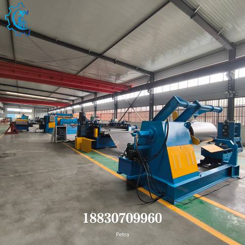 Full view of industrial steel slitting line in factory, showing decoiler, slitter, and recoiler units for metal coil processing