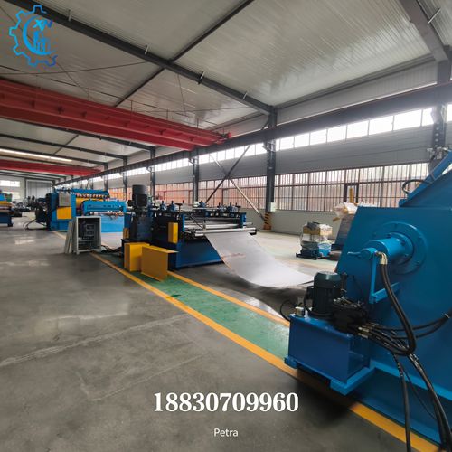 Vista panor&aacute;mica de la l&iacute;nea de corte longitudinal de bobinas de acero en f&aacute;brica, mostrando la l&iacute;nea autom&aacute;tica completa desde el desbobinador hasta el rebobinador.